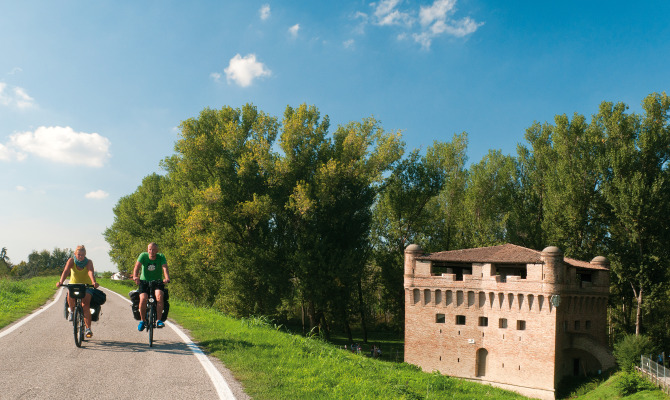 persone in bicicletta lungo il grande fiume