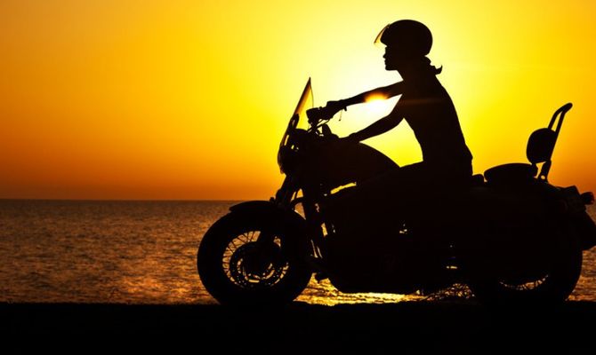 Ragazza in moto al tramonto