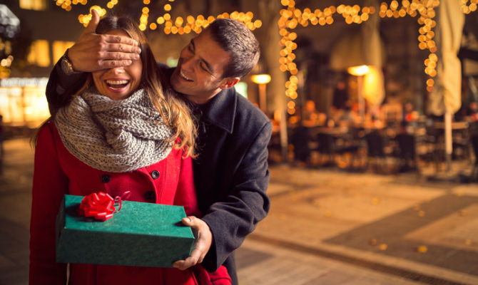 Ragazzo che regala un dono di Natale alla fidanzata