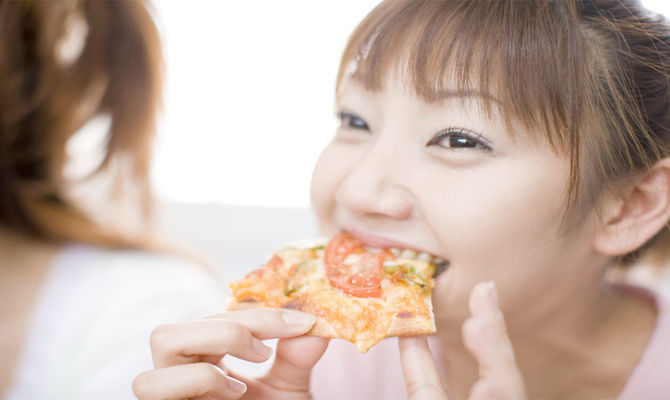 Ragazza giapponese mangia pizza
