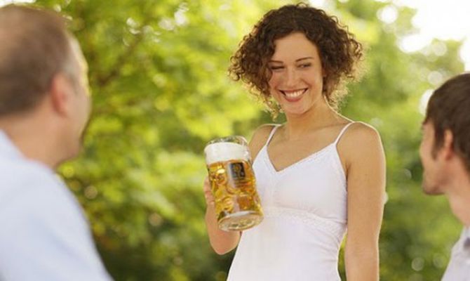 Donna con boccale di birra in un Biergarten bavarese