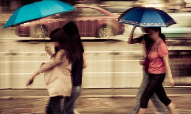 Ragazze con ombrello sotto la pioggia
