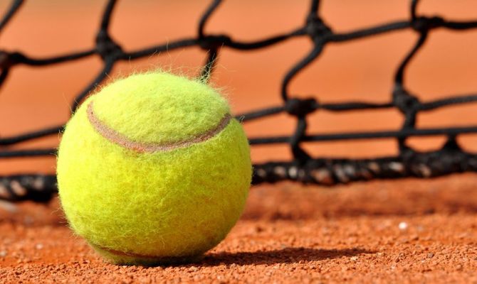 Pallina da tennis su campo rosso